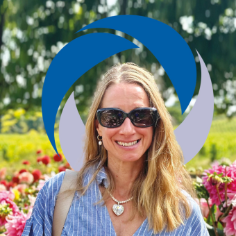 Jo Prance outside smiling with flowers behind her