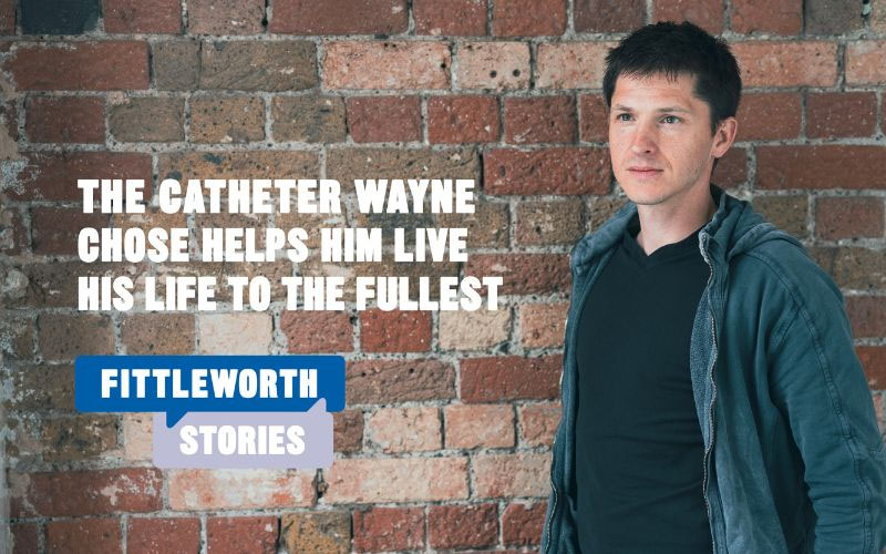 Wayne standing against a red brick wall