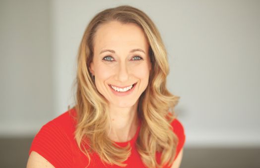 Jo Prance in red t-shirt smiling to camera
